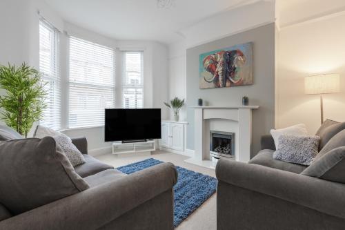 a living room with two couches and a flat screen tv at Denebank Lodge - Anfield Apartments in Liverpool