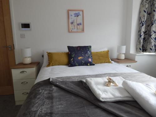 a bedroom with a bed with towels on it at Modern, well located en-suite rooms with parking and all facilities in Cambridge