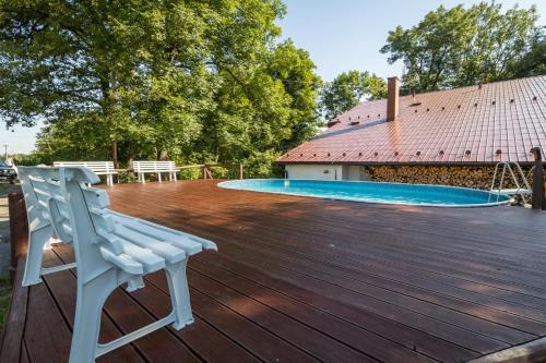 a white bench sitting on a deck next to a swimming pool at Liščí Mlýn in Frenštát pod Radhoštěm