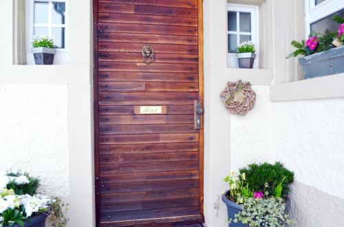 a wooden door on a house with potted plants at Hotel "Cafe Verkehrt" - Wellcome Motorbiker, Berufsleute und Reisende im Schwarzwald in Oberhof