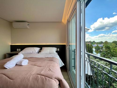 1 dormitorio con 2 camas y balcón en Cobertura Solar do Ipê Centro 2 dorm by Achei, en Canela
