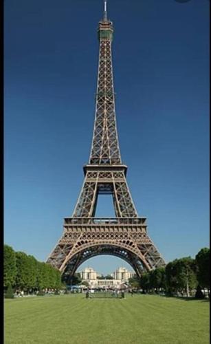 una vista de la torre Eiffel desde un campo en à 7 min de Paris, 2 pièces "Cylia résidences" à Maisons Alfort, en Maisons-Alfort