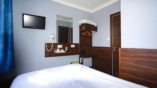 a bedroom with a bed and a tv on the wall at Crestfield Hotel in London