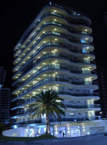 a large building with a palm tree in front of it at Sol y Luna 305 in Punta del Este