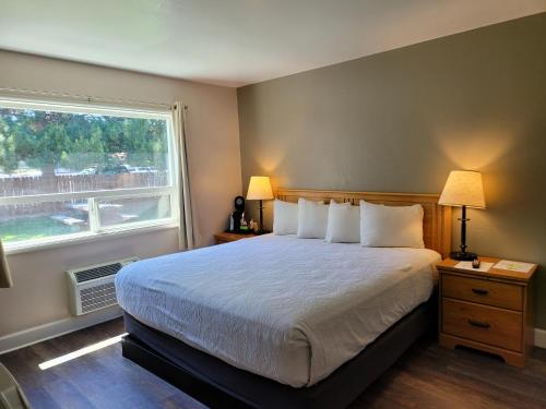Un dormitorio con una cama grande y una ventana en Bridge Street Inn, en Baker City