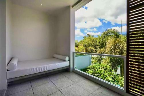 a balcony with a bench and a large window at White Lotus by Oxygen at Bang Tao Beach in Ban Thalat Choeng Thale