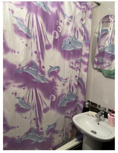 uma casa de banho com uma cortina de chuveiro com peixe em The12 отдельная комната em Bishkek