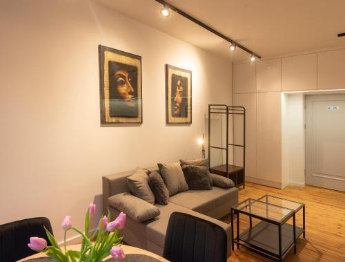 a living room with a couch and some pictures on the wall at PROVENIR HOME KWIATOWA 5 in Poznań