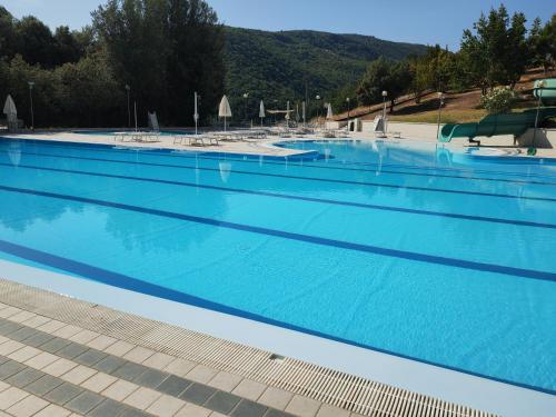 una grande piscina con acqua blu di Casa Coccinella a Nocera Umbra