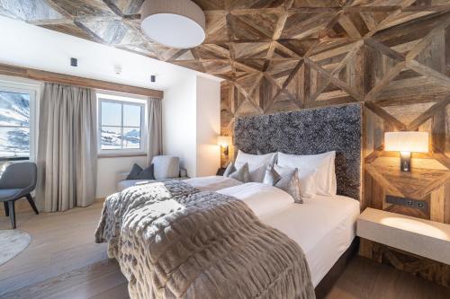 a bedroom with a large bed with a wooden ceiling at Hotel das Seekarhaus in Obertauern