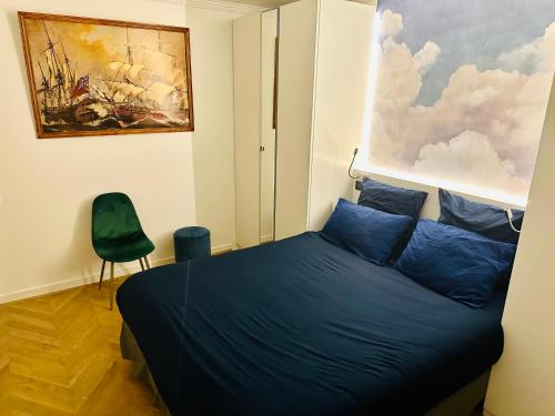 um quarto com uma cama azul e um quadro na parede em Home Sweet Home Champs de Mars em Paris