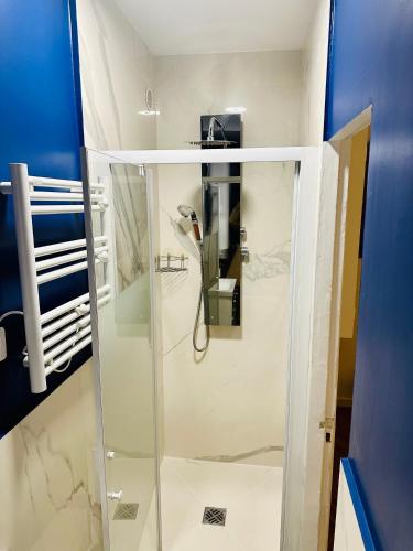 une douche avec une porte vitrée dans une salle de bain dans l'établissement Home Sweet Home Champs de Mars, à Paris