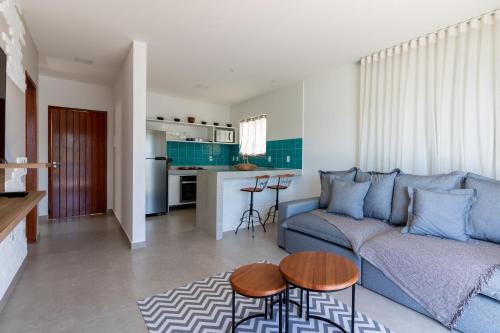 a living room with a blue couch and a kitchen at Villa Orion in Arraial do Cabo