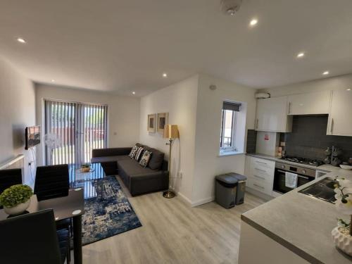 uma ampla sala de estar com um sofá e uma cozinha em Hazel 1-Bed Flat (2) + Parking em Kidlington