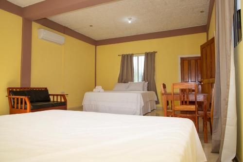 1 dormitorio con 2 camas, mesa y sillas en La Cascada Stays en San Ignacio