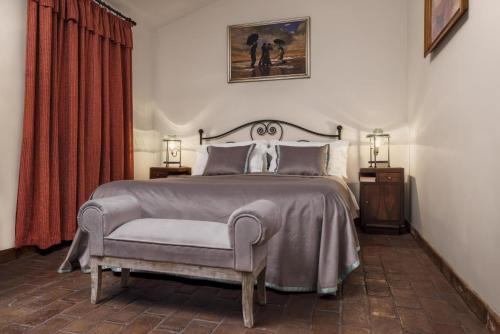 a bedroom with a large bed and a chair at Borgodoro - Natural Retreat in Magliano Sabina