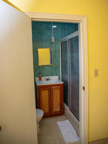 a bathroom with a toilet and a sink and a shower at Good Stays Hotel in San Ignacio