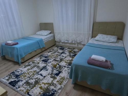 a room with two beds and a rug at Bahçeli büyük köy evi in Fethiye