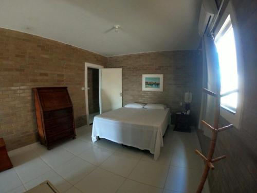 a bedroom with a white bed and a window at Solar Leão Beach in Luis Correia