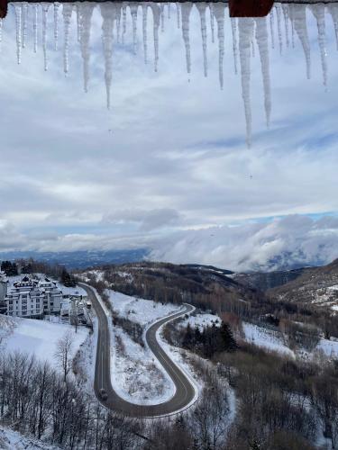 a road in the snow with icicles hanging from it at Apartmani NLUX and SPA in Kopaonik