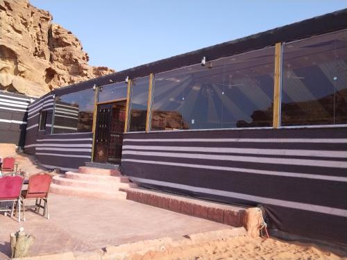 a building with stairs and chairs in front of it at The sunset of Wadi Rum in Wadi Rum