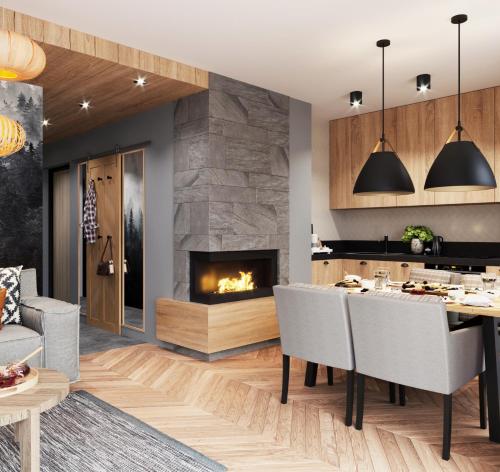 a kitchen and dining room with a fireplace at Apartamenty Skrzyczne in Szczyrk