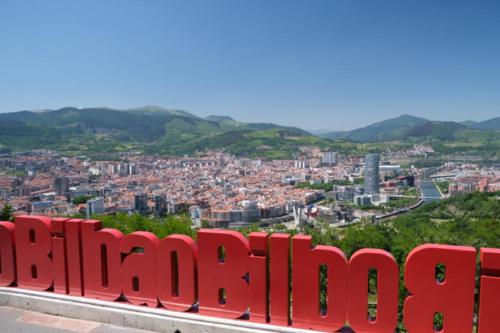 a view of a city from a red sign at Apartamento Portugalete Gran Bilbao 3 dormitorios - 3 bedrooms in Portugalete