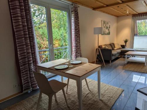 sala de estar con mesa, sillas y sofá en Ferienwohnung am Schönberg - Ebringen, en Ebringen