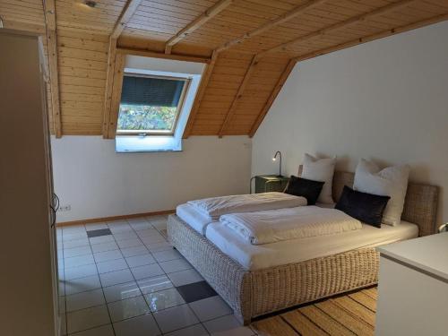 1 dormitorio con cama y ventana en Ferienwohnung am Schönberg - Ebringen, en Ebringen