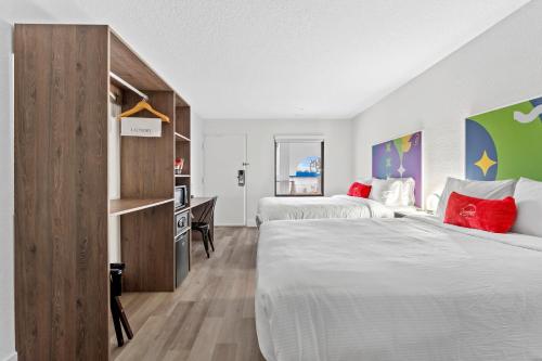 a bedroom with two beds and a desk at Baymont by Wyndham Jacksonville Airport in Jacksonville