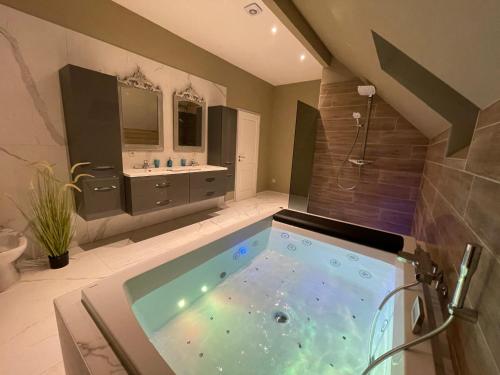 a large bathroom with a tub with a sink at le gite des chantoires in Aywaille