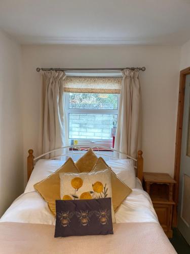 Schlafzimmer mit einem Bett und einem Fenster in der Unterkunft Rose Cottage room Bee Happy in Newquay