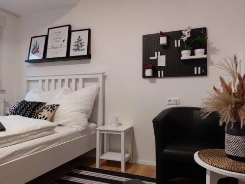 a bedroom with a bed and a chair and a table at Rooftop Apartmens Ulm - komfortable neue Gemeinschaftsunterkunft im Herzen von Ulm - Raum 2 in Ulm