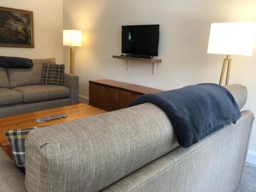 Polmood的住宿－Glenheurie Cottage，带沙发和电视的客厅