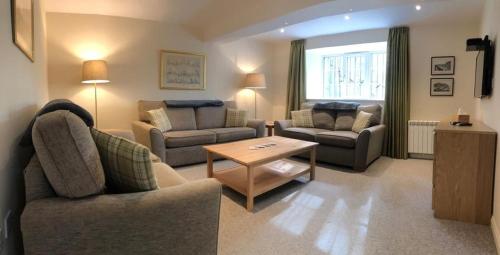 a living room with two chairs and a coffee table at Lategillan Cottage in Polmood