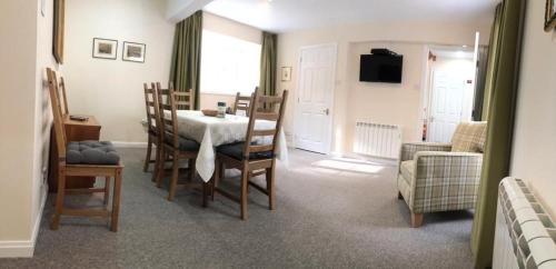 a living room with a dining room table and chairs at Lategillan Cottage in Polmood