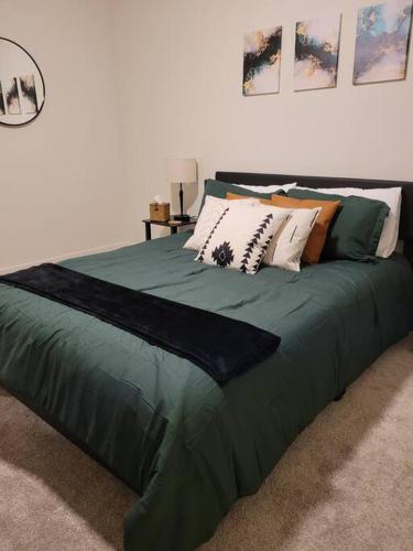 a large green bed with many pillows on it at Downtown SLC Apt w/amenities in Salt Lake City
