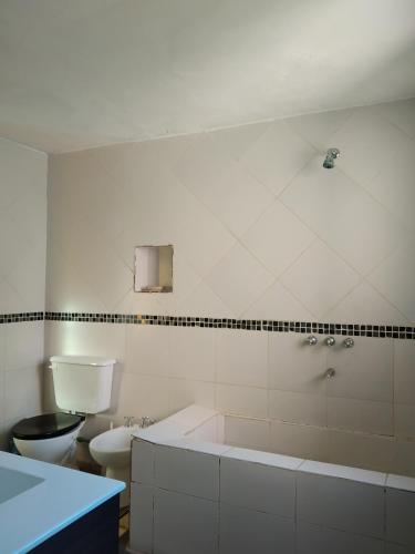 a white bathroom with a tub and a toilet at Finca La Codiciada in San Rafael
