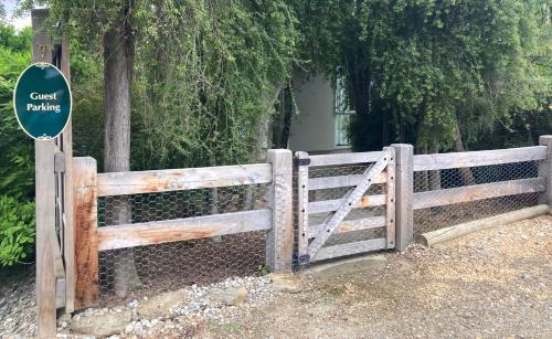 a wooden fence with a gate with a sign on it at Lookout Escape Studio, Alexandra in Alexandra