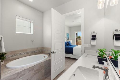 a white bathroom with a tub and a bed at Ocotillo Springs Resort 45 l Brand New Property, Private Pool, Hot Tub, & Community Pool in Santa Clara