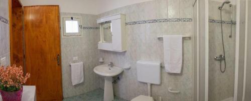y baño con lavabo, aseo y espejo. en Pajara Chicca, en Morciano di Leuca