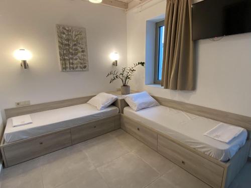 two beds in a room with a window at Matala Prime Villas in Matala