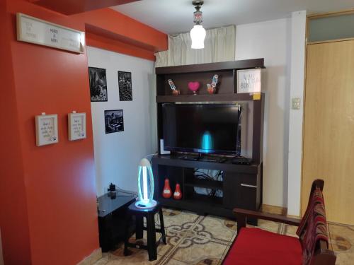 uma sala de estar com televisão e um banco em Cozy apartment in cusco em Cusco