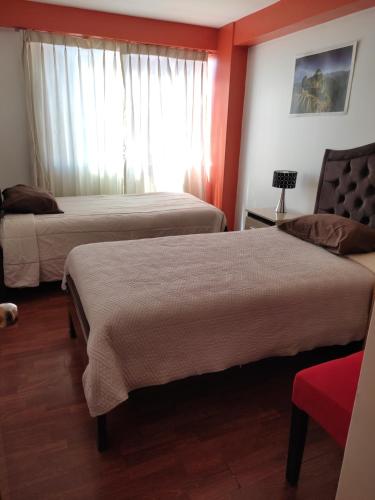 um quarto de hotel com duas camas e uma janela em Cozy apartment in cusco em Cusco