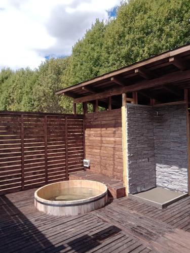 a hot tub on a wooden deck with a fence at PARCELA DE AGRADO CON PISCINA LAGO RANCO todas las instalaciones con uso exclusivo capacidad 20 personas in Lago Ranco