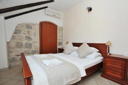 ein Schlafzimmer mit einem großen Bett und einer Steinmauer in der Unterkunft Lady of the Rocks apartments in Perast