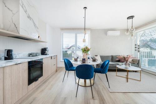 a kitchen and living room with a table and chairs at Pearl Apartment by LoftAffair in Gdańsk