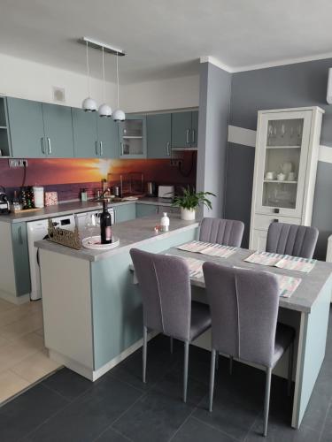 a kitchen with a table and chairs in a kitchen at Krisztina Apartman in Salgótarján