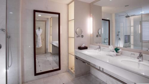 a bathroom with two sinks and a shower and a mirror at Grand Victoria Hotel in Taipei