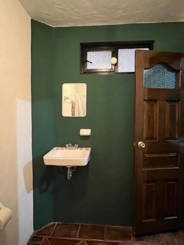 a bathroom with a sink and a green wall at GRUPO MARMIL in San Juan